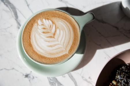 an expertly crafted latte in a light blue mug on a marble counter at Persephone Bakery in Jackson, WY