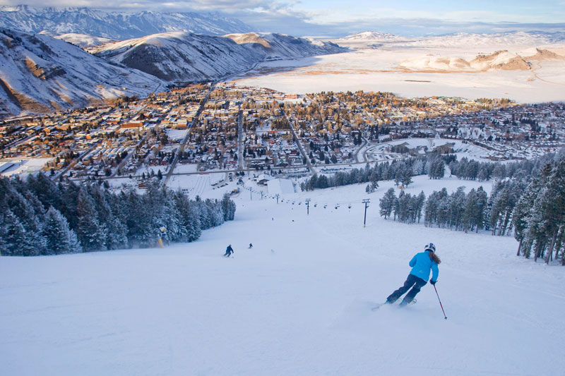 people skiing down the mountain at Snow King Mountain toward the town of Jackson Hole