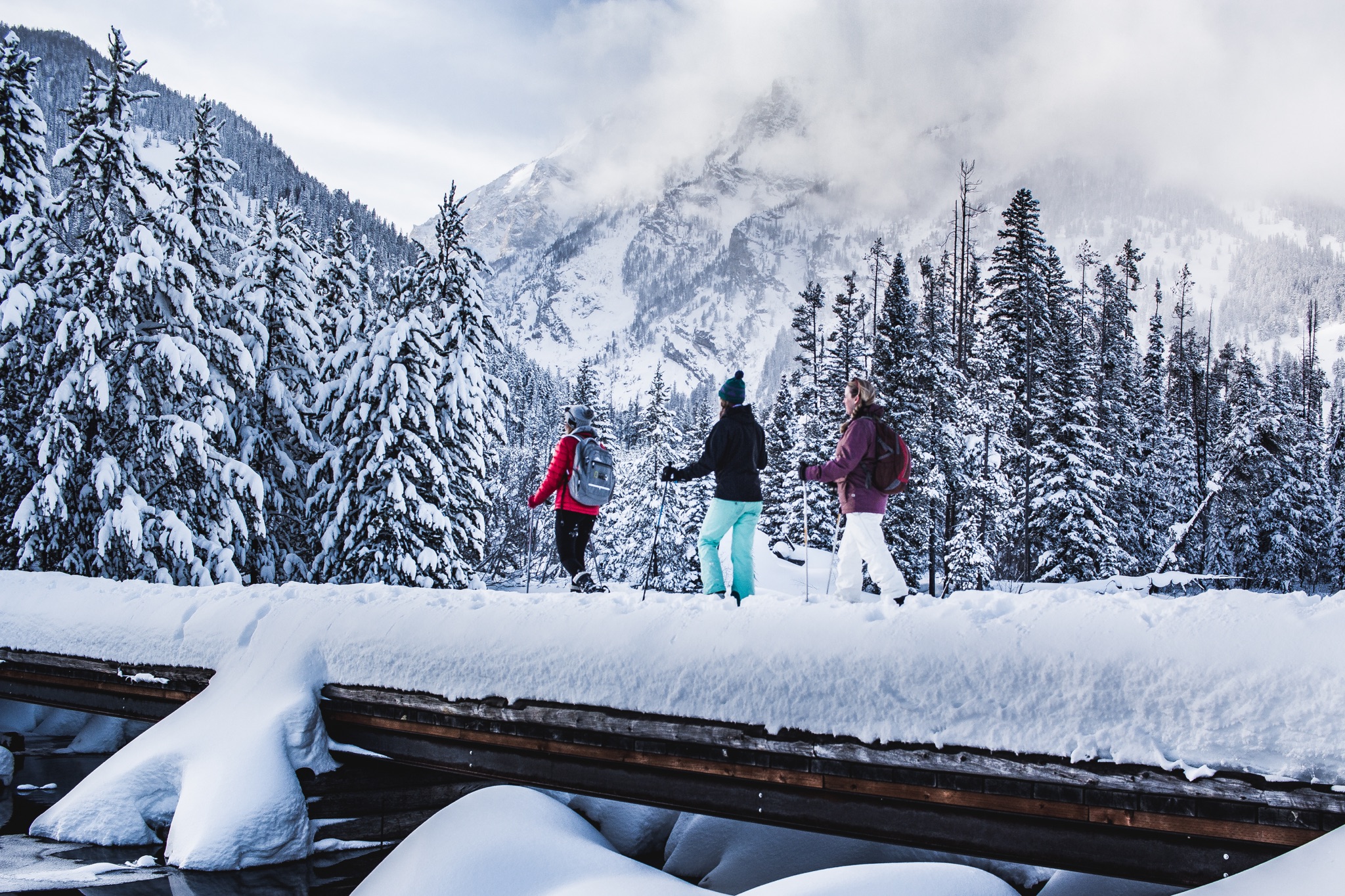 three people snowshoeing in the backcountry during winter in jackson Hole