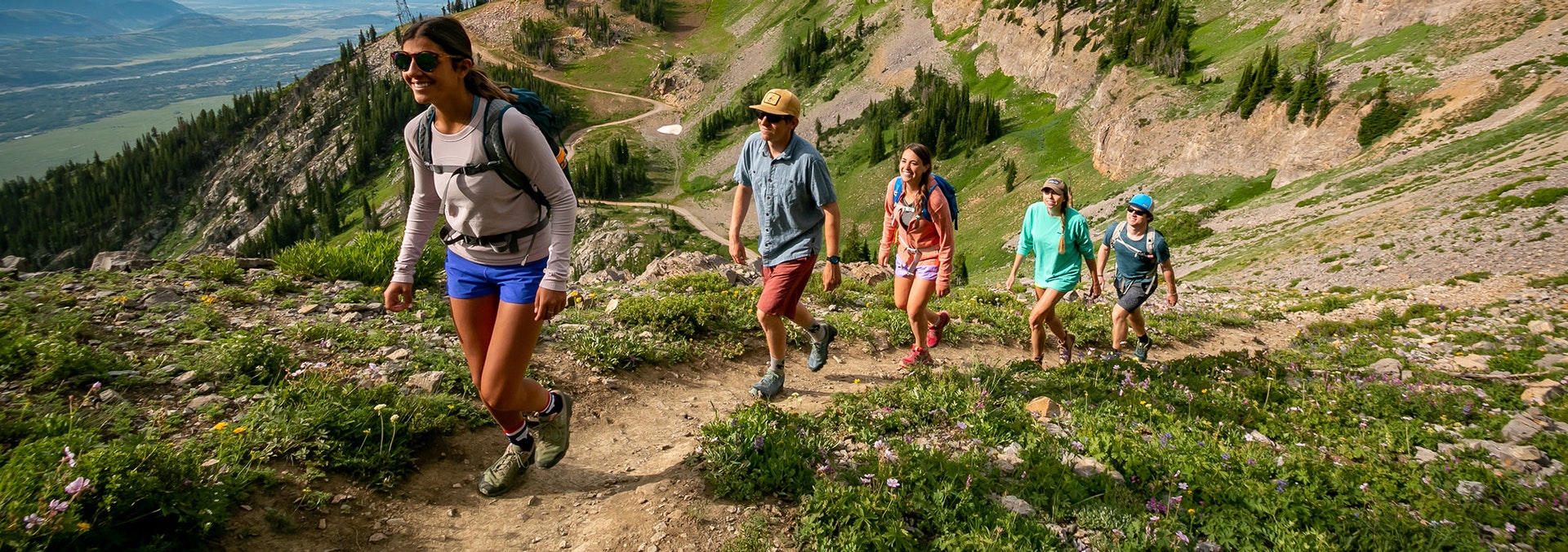 a group of five hike through the mountains in Jackson Hole, WY