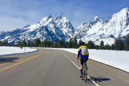 a person bikes by snow covered mountains