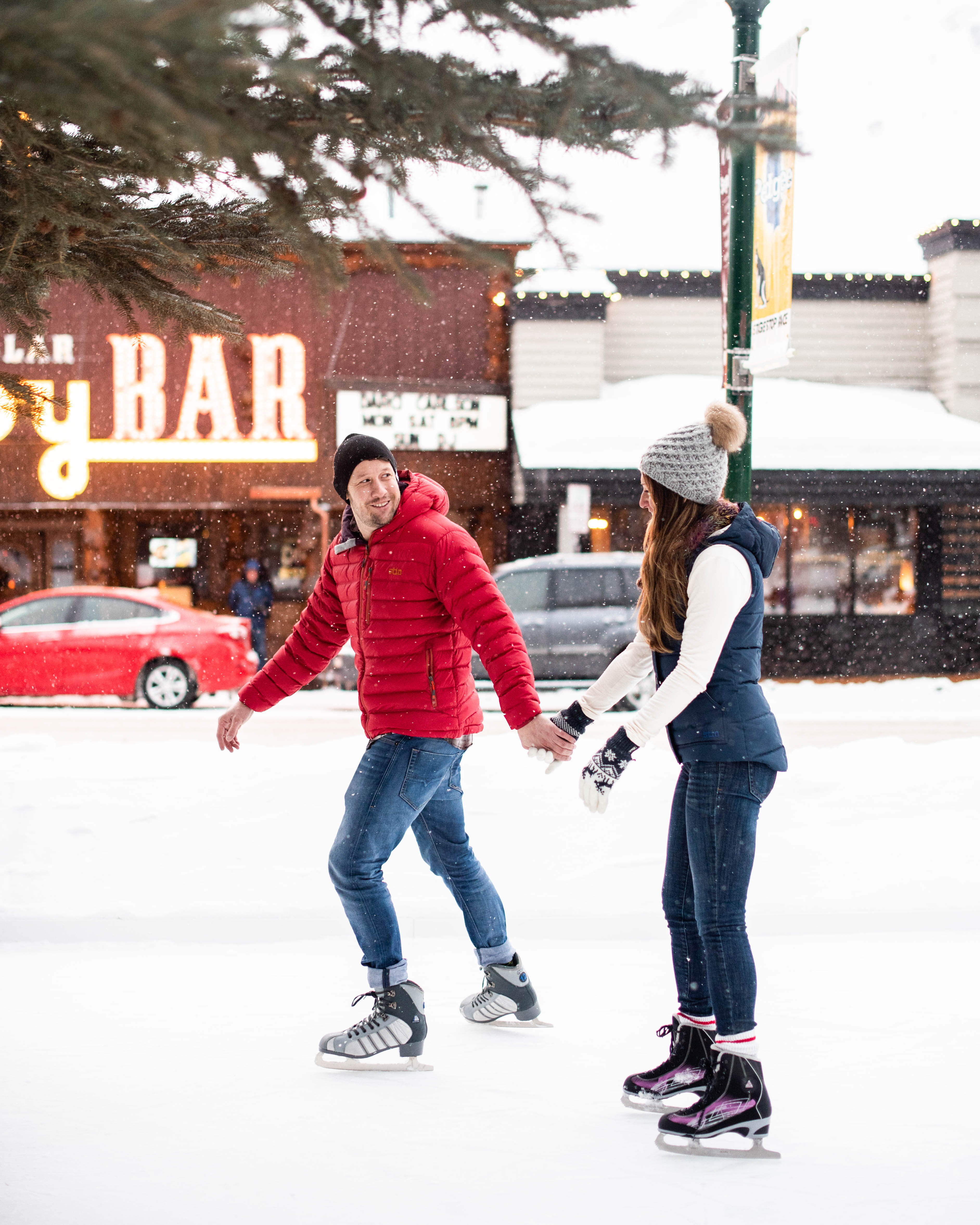 A couple ice skates in front of the Million Dollar Cowboy Bar in Jackson Hole