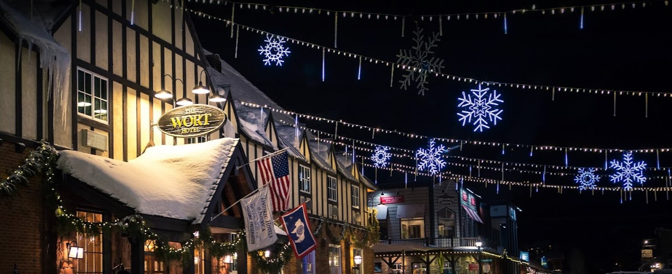 holiday lights and glowing snowflakes hang from a snow covered Wort Hotel