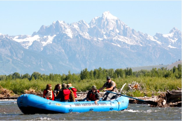 a group enjoys scenic views while rafting through Grand Teton National Park