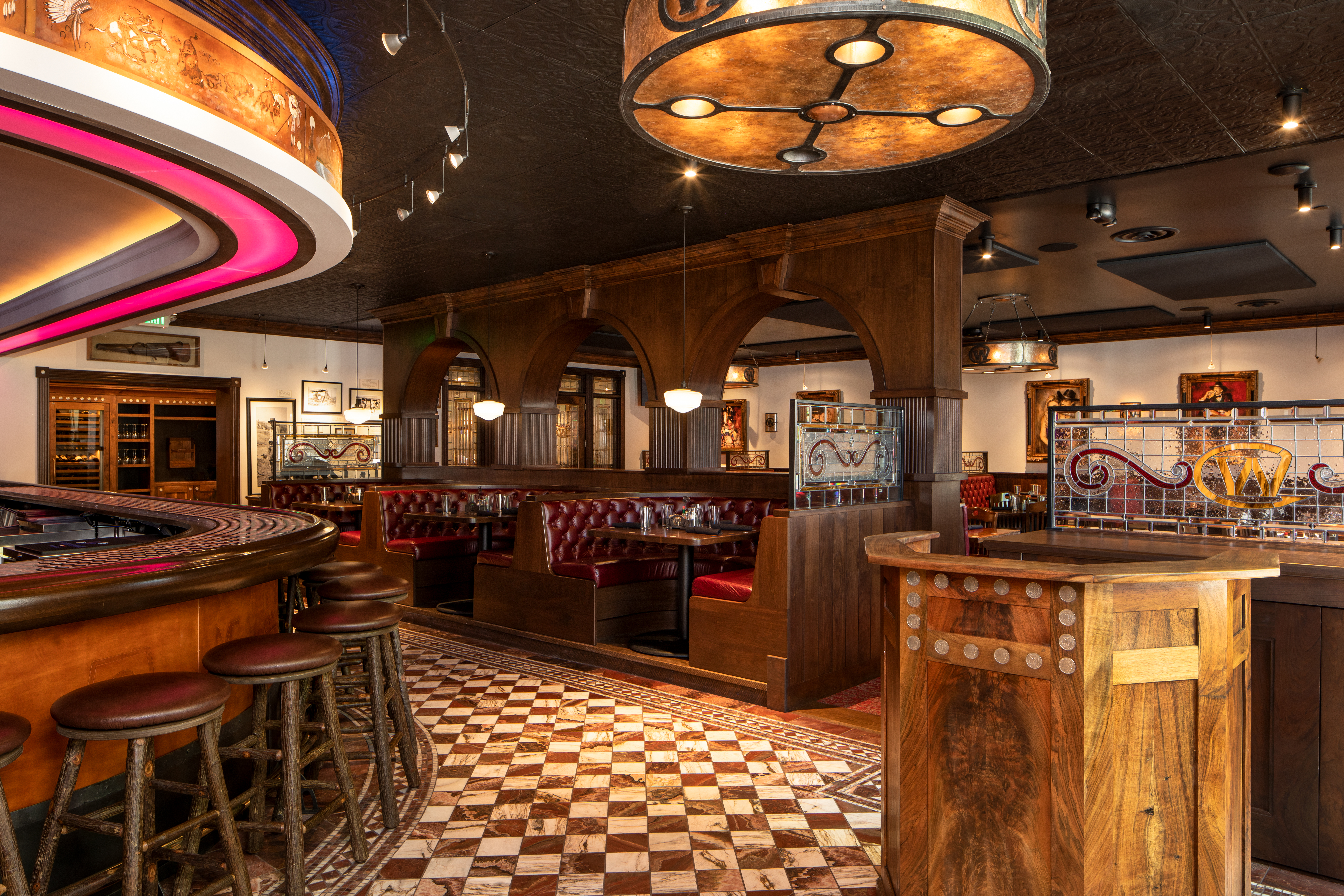 Interior of the Silver Dollar Bar. A curve bar is on the left and leather booths fill the restaurant